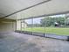 Relaxing outdoor patio with screened enclosure offering views of the green yard and mature trees at 1332 Osceola Hollow Rd, Odessa, FL 33556