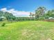 Expansive green yard with lush grass and trees, partially enclosed by a rustic wooden fence at 1332 Osceola Hollow Rd, Odessa, FL 33556