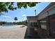Relaxing community pool area with lounge chairs, palm trees, and a glimpse of the lake at 13758 Orange Sunset Dr # 202, Tampa, FL 33618