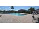 Inviting community pool surrounded by a spacious deck, palm trees, and manicured landscaping at 13758 Orange Sunset Dr # 202, Tampa, FL 33618