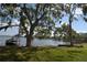 Scenic waterfront view with mature trees, a boat, and a tranquil lake at 13758 Orange Sunset Dr # 202, Tampa, FL 33618