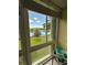 Balcony view of lake with bench seat and clear blue sky at 1408 Millstream Ln # 206, Dunedin, FL 34698