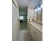 Bathroom with vanity leading into room with neutral carpet and minimalist decor at 1408 Millstream Ln # 206, Dunedin, FL 34698