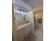 Bright bathroom featuring a dual vanity, ample storage, and black and white tile at 1408 Millstream Ln # 206, Dunedin, FL 34698