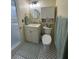 Updated bathroom with white vanity, medicine cabinet, and toilet with patterned tile flooring at 1408 Millstream Ln # 206, Dunedin, FL 34698
