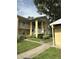 Inviting two-story condo featuring well-maintained landscaping, a sidewalk, and convenient stair access to all units at 1408 Millstream Ln # 206, Dunedin, FL 34698
