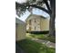 Charming condo building showcasing well-kept grounds, a sidewalk, a mature shade tree, and dedicated exterior storage at 1408 Millstream Ln # 206, Dunedin, FL 34698