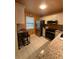 Modern kitchen showcasing stainless steel appliances, granite countertops, tile flooring, and bright lighting for a functional design at 1408 Millstream Ln # 206, Dunedin, FL 34698