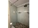 Recently updated shower with green subway tiling and a pebble stone floor at 1408 Millstream Ln # 206, Dunedin, FL 34698