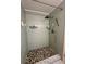 Beautiful shower with green tile and a pebble stone floor providing spa like features at 1408 Millstream Ln # 206, Dunedin, FL 34698