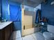 Compact bathroom features a combined tub and shower with blue tiles at 14210 Downing St, Dover, FL 33527