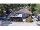 An exterior view of the home featuring a covered porch and vibrant landscaping at 14210 Downing St, Dover, FL 33527