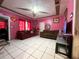 Inviting living room featuring bright pink walls, tile floors, and comfortable seating at 14210 Downing St, Dover, FL 33527