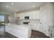 Bright and modern kitchen with an island, stainless appliances, and white cabinets at 14411 Meadow Bird Ave, Riverview, FL 33579