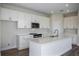 Well-lit kitchen boasting stainless steel appliances, white cabinets, and a spacious island at 14411 Meadow Bird Ave, Riverview, FL 33579