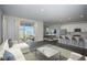 Open-concept living space with a modern kitchen, stainless appliances, large island, and sliding glass doors to the backyard at 14411 Meadow Bird Ave, Riverview, FL 33579