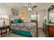 Bedroom with a four-poster bed, wood-look floors, lamps, dresser and nightstand at 1535 Nursery Rd # 110, Clearwater, FL 33756