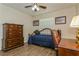 Cozy bedroom featuring wood-look floors, a daybed, and matching wooden dresser and desk set at 1535 Nursery Rd # 110, Clearwater, FL 33756