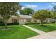 Charming one-story home with a manicured lawn, tidy landscaping, and a concrete path to the front door at 1535 Nursery Rd # 110, Clearwater, FL 33756