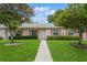 Charming one-story home featuring a well-manicured lawn, colorful shutters, and inviting walkway to the front door at 1535 Nursery Rd # 110, Clearwater, FL 33756