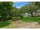 Grassy residential common ground with lush trees and distant parking at 1535 Nursery Rd # 110, Clearwater, FL 33756