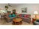 Inviting living room featuring floral patterned sofas, wood-look floors, and view to kitchen at 1535 Nursery Rd # 110, Clearwater, FL 33756