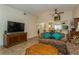 Comfortable living room with floral patterned sofas, wood-look floors, and view to kitchen at 1535 Nursery Rd # 110, Clearwater, FL 33756