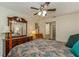Comfortable main bedroom with a ceiling fan, ensuite bathroom, and a wooden dresser with large mirror at 1535 Nursery Rd # 110, Clearwater, FL 33756