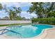 Community pool surrounded by a fence and lush landscaping, providing a private and serene oasis at 1535 Nursery Rd # 110, Clearwater, FL 33756