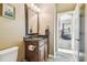 Charming half-bathroom with vanity featuring a granite countertop, decorative mirror, and tile floors at 16248 Ivy Lake Dr, Odessa, FL 33556