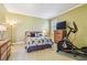Cozy bedroom with natural light, comfortable bed, and space for exercise equipment at 16248 Ivy Lake Dr, Odessa, FL 33556