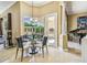 A dining room featuring a glass table, seating for four, and a view of the backyard and pool at 16248 Ivy Lake Dr, Odessa, FL 33556