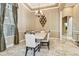 Elegant dining room featuring marble floors, decorative walls, and a stylish chandelier above the table at 16248 Ivy Lake Dr, Odessa, FL 33556