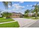 Beautiful single-story home with a three-car garage, brick driveway, and mature palm trees at 16248 Ivy Lake Dr, Odessa, FL 33556