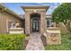 Beautiful brick-accented front entrance with black double doors, stone columns, and lush landscaping at 16248 Ivy Lake Dr, Odessa, FL 33556