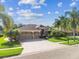 Spacious single-Gathering home with a three-car garage, brick-paved driveway, and lush landscaping at 16248 Ivy Lake Dr, Odessa, FL 33556