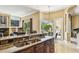 A kitchen featuring granite countertops, a stainless steel sink, wood cabinets, and a view into the living room at 16248 Ivy Lake Dr, Odessa, FL 33556