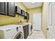 Functional laundry room featuring modern washer and dryer, storage cabinets, and a convenient countertop at 16248 Ivy Lake Dr, Odessa, FL 33556
