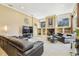A spacious living room featuring a large TV, dark leather sofas, built-in shelves, and lots of natural light at 16248 Ivy Lake Dr, Odessa, FL 33556