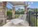 Outdoor lounge area featuring stone columns, overhead shade, and comfortable chaise lounges at 16248 Ivy Lake Dr, Odessa, FL 33556