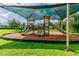 Community playground features slides, swings, and climbing structures under a sunshade at 16248 Ivy Lake Dr, Odessa, FL 33556