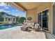 Covered outdoor patio area with a fireplace, view of pool, and comfortable seating at 16248 Ivy Lake Dr, Odessa, FL 33556