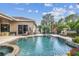 Backyard pool with patio, a hot tub, and meticulously maintained landscaping at 16248 Ivy Lake Dr, Odessa, FL 33556