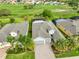 Aerial view of a well-maintained home with a screened pool, three-car garage, and lush green surroundings at 1723 Pacific Dunes Dr, Sun City Center, FL 33573