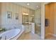 Elegant bathroom with a soaking tub, glass-enclosed shower, and coordinated wallpaper at 1723 Pacific Dunes Dr, Sun City Center, FL 33573