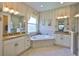 Bright bathroom featuring a large tub, dual sinks, and striped wallpaper at 1723 Pacific Dunes Dr, Sun City Center, FL 33573