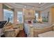 Spacious bedroom with a tray ceiling, hardwood floors, and a comfortable seating area at 1723 Pacific Dunes Dr, Sun City Center, FL 33573