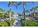 Community pool area featuring a pool, tables, umbrellas and a pathway surrounded by landscaping at 1723 Pacific Dunes Dr, Sun City Center, FL 33573