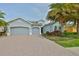 Charming home featuring a three-car garage, beautiful landscaping, and a brick driveway for added curb appeal at 1723 Pacific Dunes Dr, Sun City Center, FL 33573