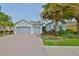 Charming home featuring a three-car garage, beautiful landscaping, and a brick driveway for added curb appeal at 1723 Pacific Dunes Dr, Sun City Center, FL 33573